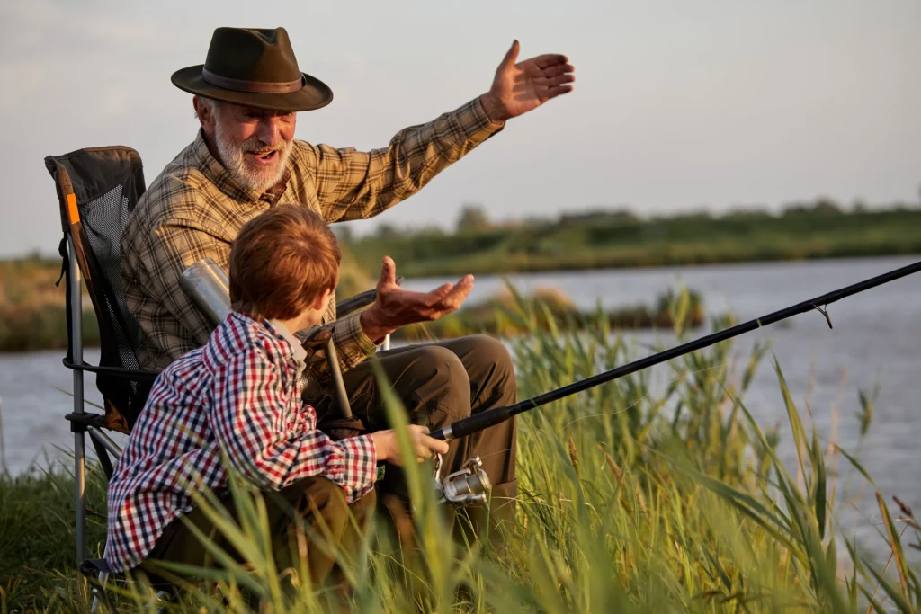 Retirement lifestyle symbolized by grandfather fishing with grandson, supported by wealth management planning.