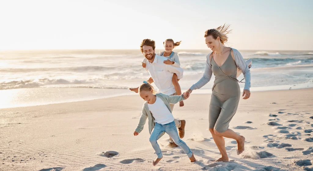 Family enjoying financial freedom and quality time at the beach thanks to smart wealth and retirement planning.