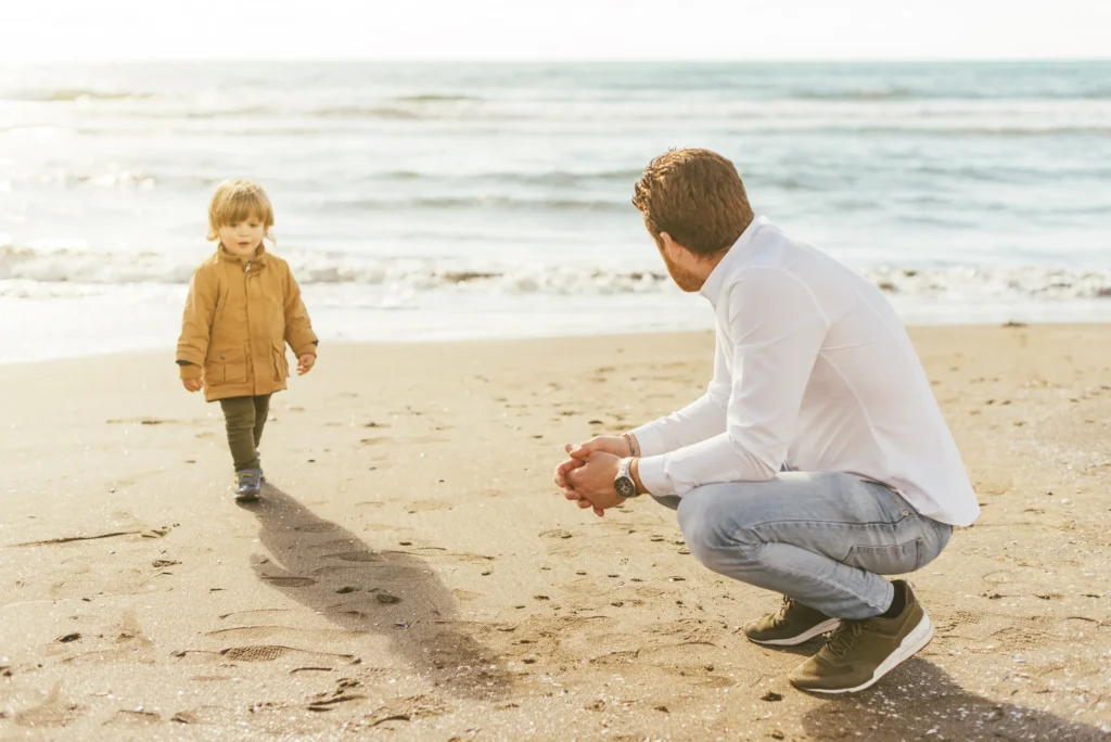 Parent enjoying quality time at the beach with child, symbolizing financial freedom through smart planning.